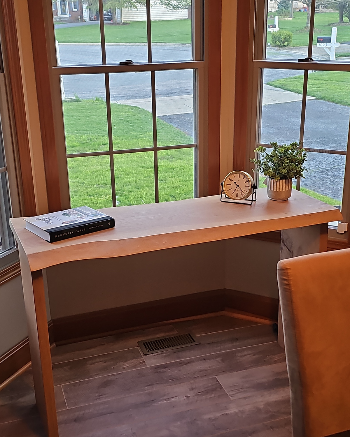 Full view of Meridian placed below two windows with books, clock, and plant