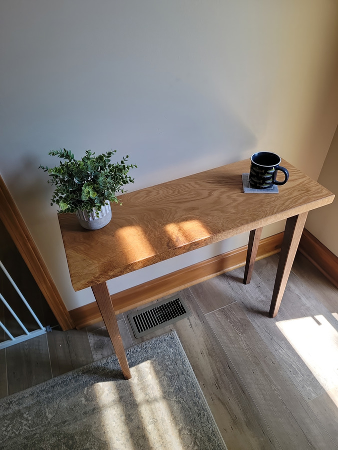 Northstar white oak and walnut console styled with a plant and mug in warm window light