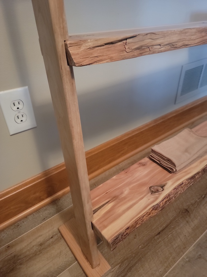 Close view of Rise shelf joinery, maple upright, and floor-extension foot