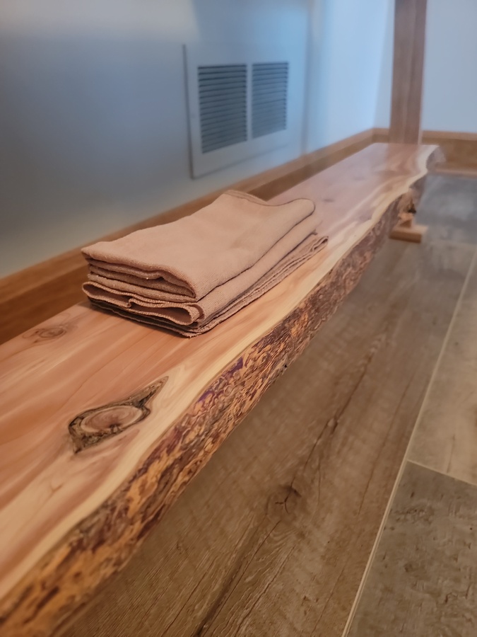Close detail of a live-edge cedar shelf on Rise