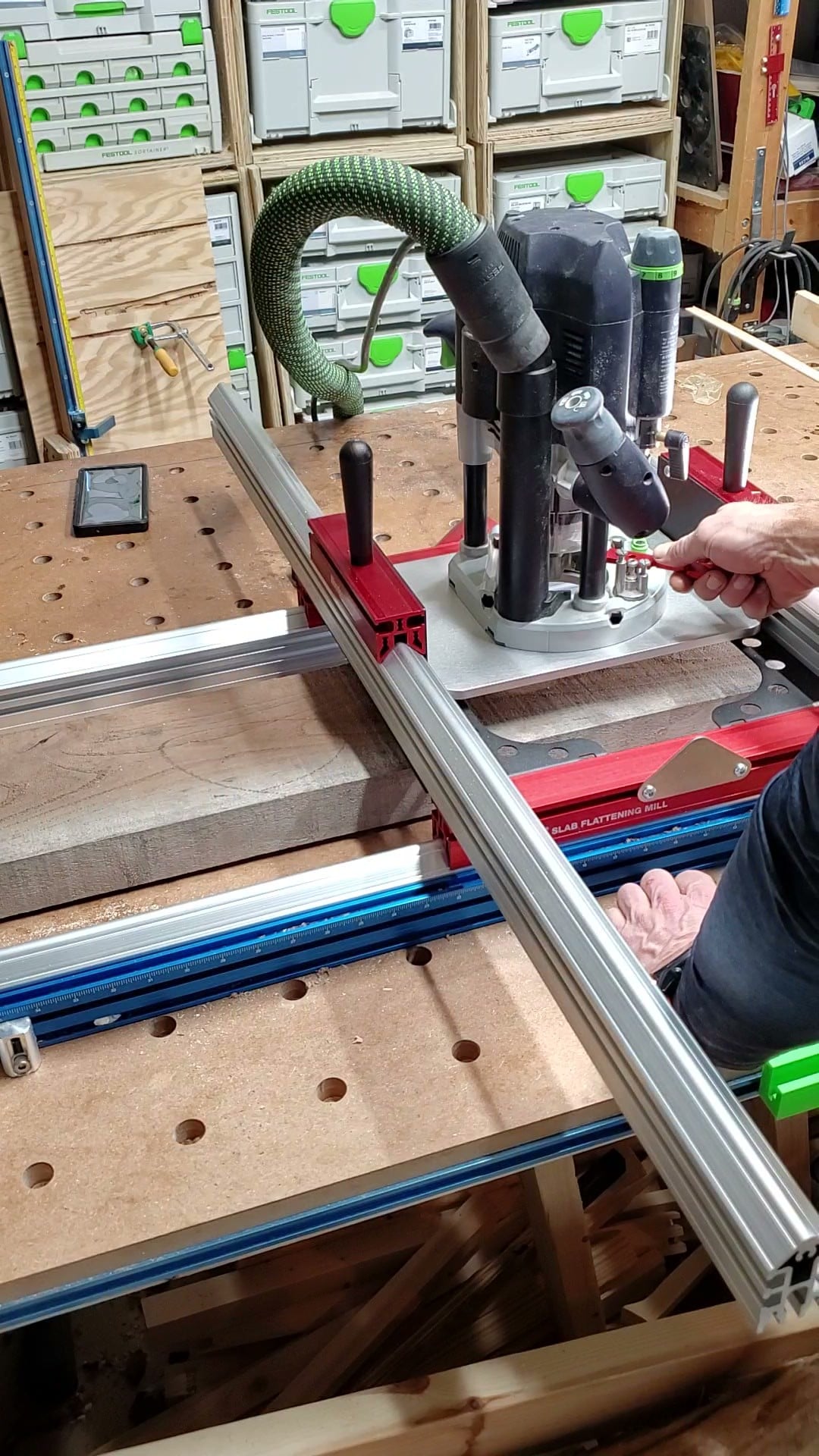 Steve Moore flattening a hardwood slab with a router sled in The Sawdust Sanctuary workshop in Powell, Ohio